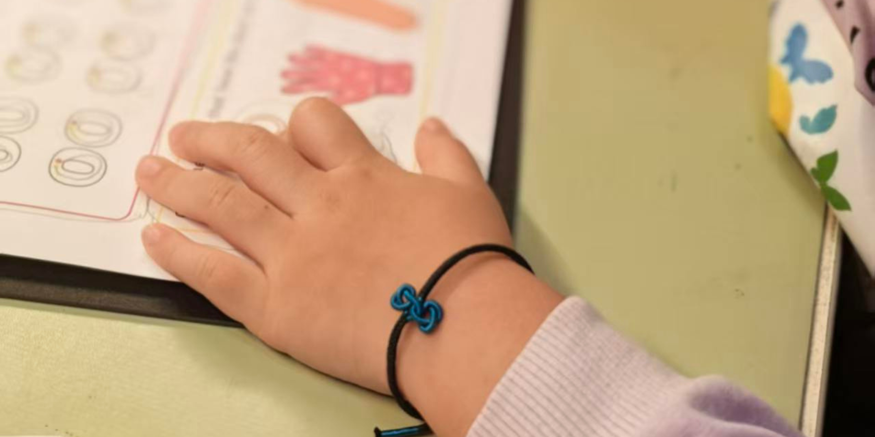 a kid wearing a string bracelet