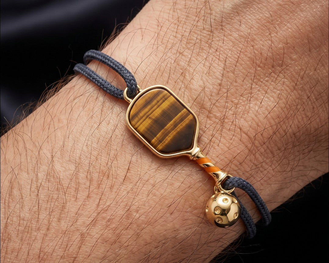 man wearing a black string bracelet with pickleball paddle charm