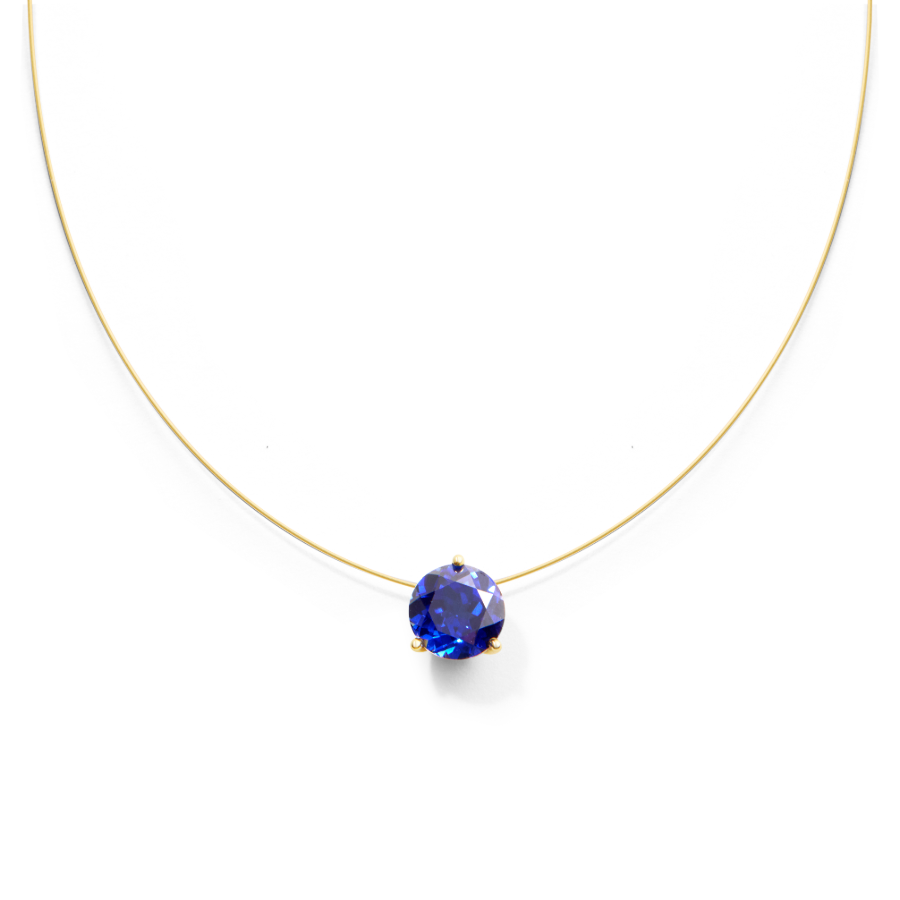 Gold nylon necklace with a blue sapphire on a white background