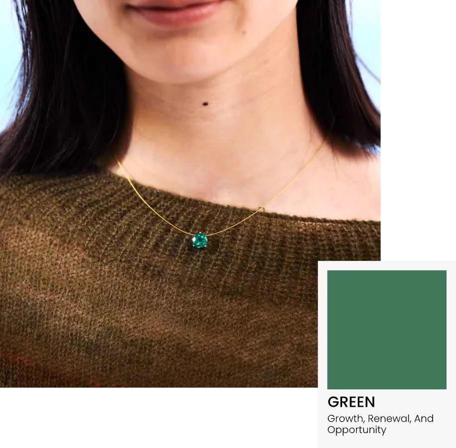 Person wearing a Glint & Luck's floating necklace with a green pendant, set against a neutral background.