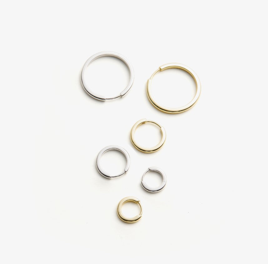 Set of gold and silver hoop earrings on a white background