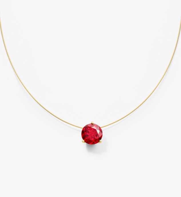 Gold nylon wire necklace with a lab grown ruby on a white background