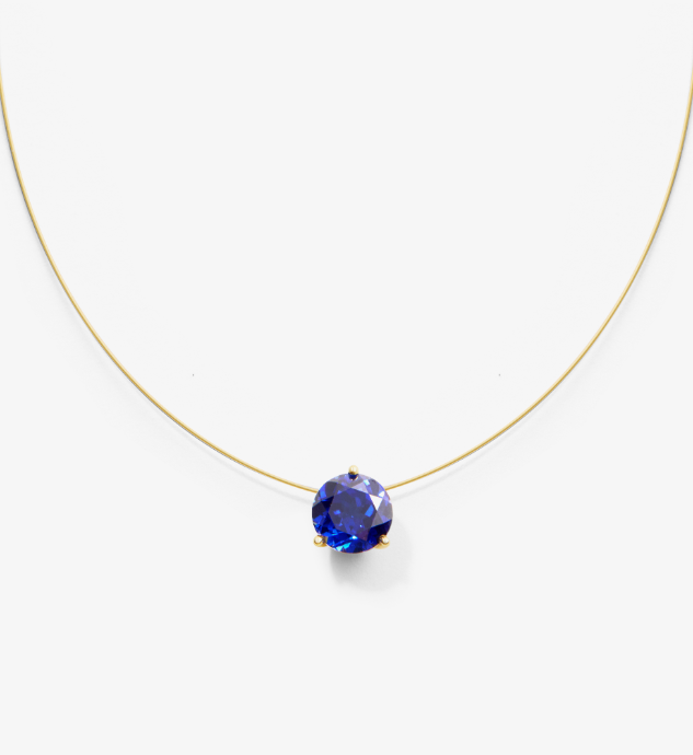 Wire necklace with a blue lab grown sapphire on a white background