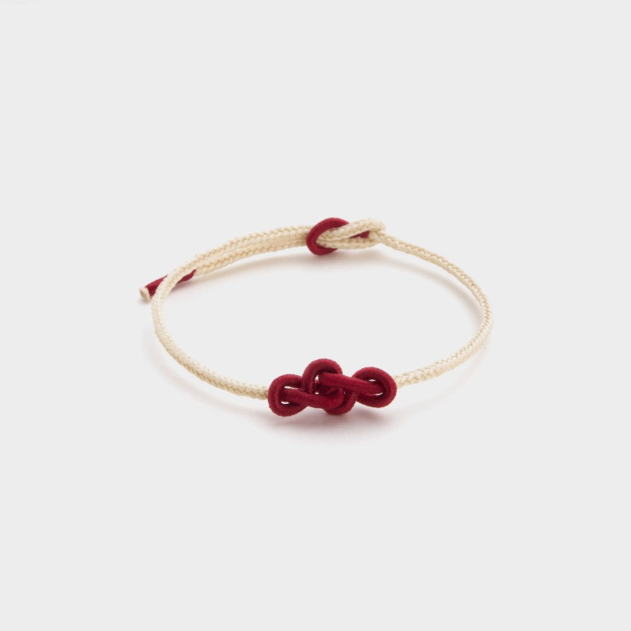 white string bracelet with a red ruyi knot