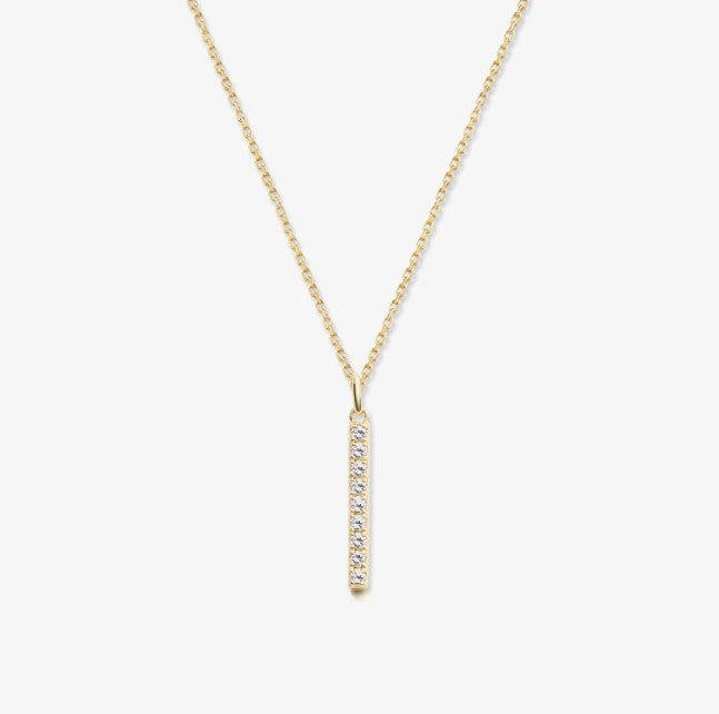 Gold bar necklace with white sapphires on a white background