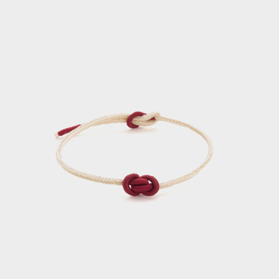 white string bracelet with a red yuanbao knot