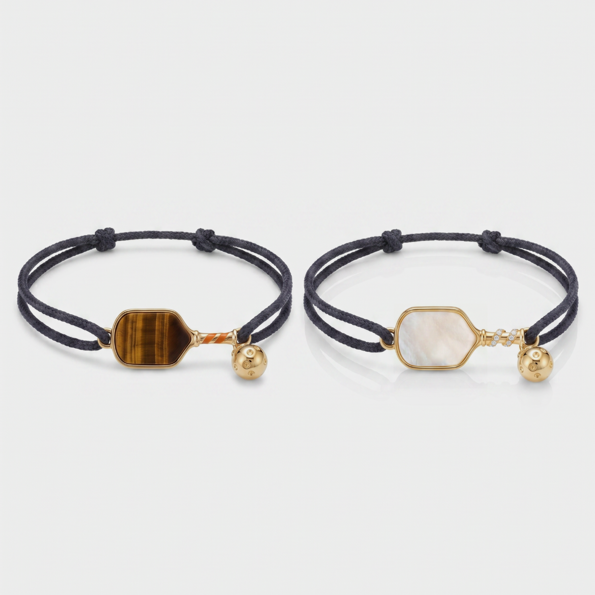 Two black cord bracelets with gemstone pickleball paddle charms on a light gray background